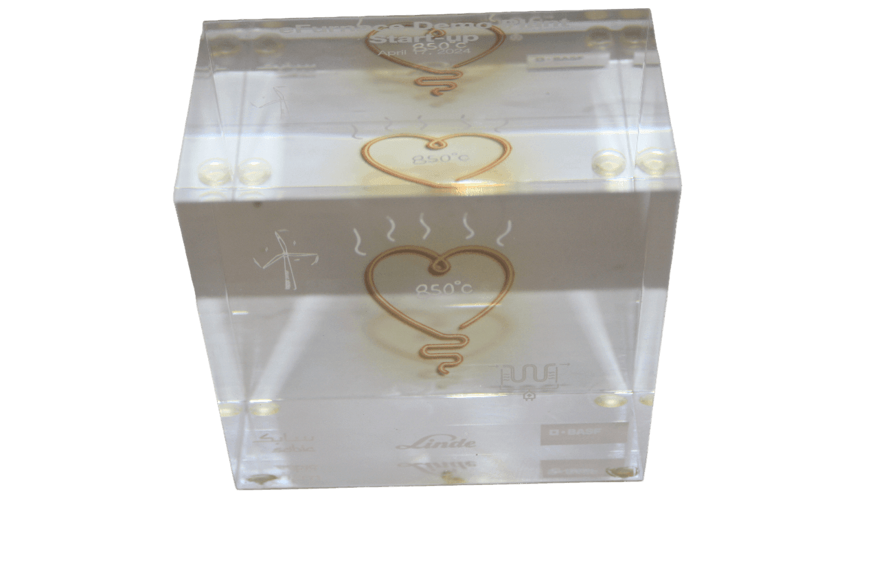 Transparent block with etched symbols and heart shape marked 850°C, featuring various logos.